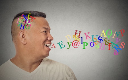 Side view portrait young handsome man talking with alphabet letters coming out of open mouth...