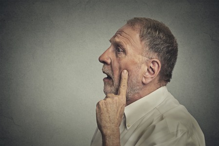 Portrait worried man thinking looking up isolated on grey wall background with copy space. Human face expressions, emotions, feelings, body language, perceptionの写真素材