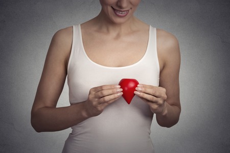 Closeup cropped image young woman holding red drop of blood isolated on gray wall backgroundの写真素材