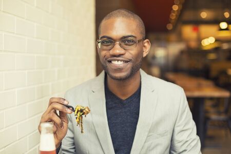 Young handsome man eating mixed vegetable meal in cafe chain restaurantの写真素材
