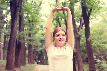 Fitness woman stretching exercises on fresh air. Beautiful sportswoman exercising outdoors in park...