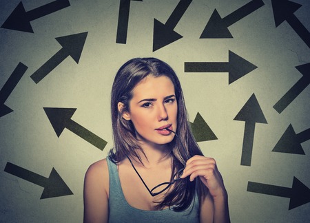Doubtful confused skeptical young woman on gray wall background. Human face expression reaction perceptionの写真素材