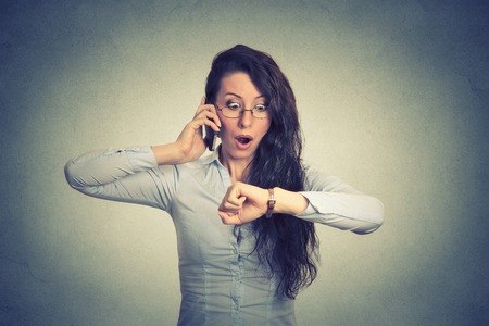 Business and time management concept. Stressed businesswoman looking at wrist watch, running late for meeting Business and time management concept. Stressed businesswoman looking at wrist watch, running late for meeting