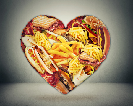 Heart health and bad diet stroke risk concept. Heart shaped of fast junk fatty foodの写真素材