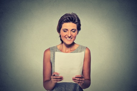tax, finances, happiness concept. Smiling young woman with papers on gray wall backgroundの写真素材
