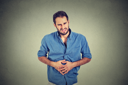 Young man with stomach pain indigestionの写真素材