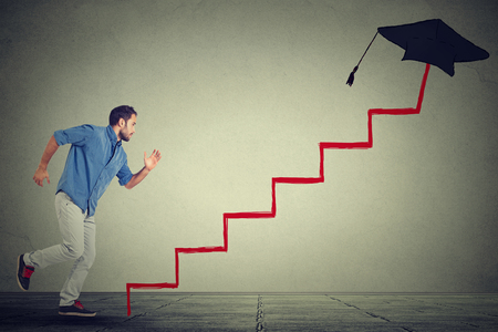 Concept of education target progress. Young man student running up career education ladderの写真素材