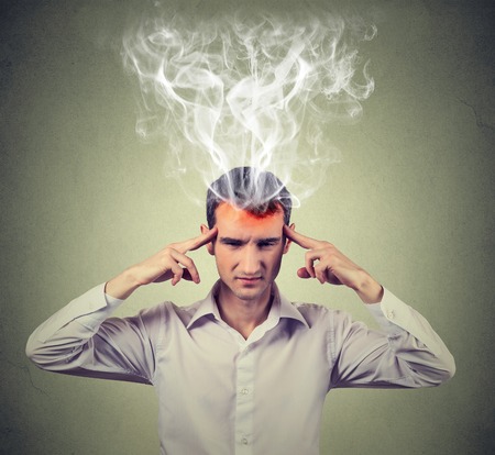 man thinks very intensely having headache isolated on gray wall background. human face expressionの写真素材