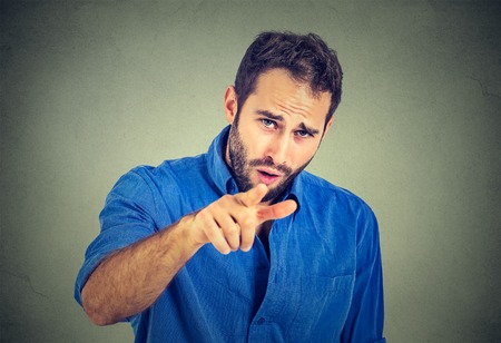 portrait of a angry young man pointing finger at someoneの写真素材