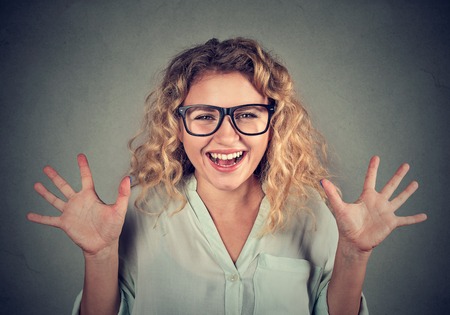 super excited funky looking girl in glasses screaming isolated on gray wall backgroundの写真素材