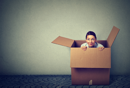 Young woman coming out from a box
