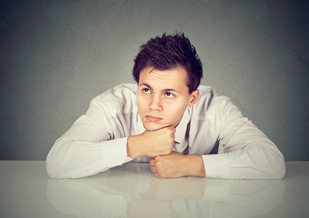 Bored young man daydreaming showing no interest 