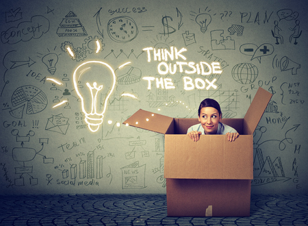 Think outside the box concept. Young woman coming out of box isolated on gray info graphic wall background