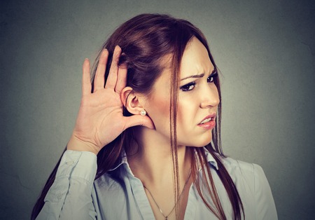 Curious worried woman with hand to ear carefully secretly listening to gossip conversation isolated...