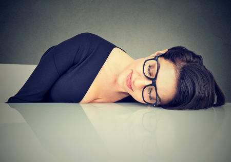 Woman sleeping on a deskの写真素材