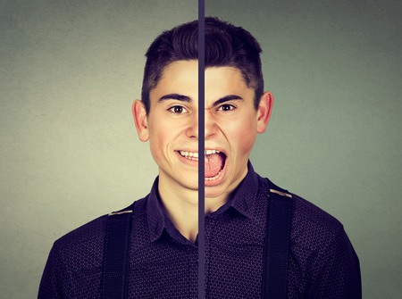 Bipolar disorder concept. Young man with double face expression isolated on gray backgroundの写真素材