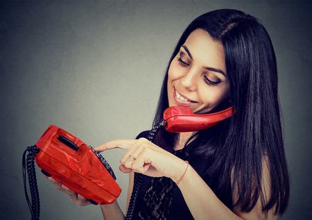 Young woman on the phone dialing the numberの写真素材