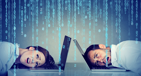 Stressed business woman and man resting head on laptop under binary code rain sitting at table frustrated with each otherの写真素材