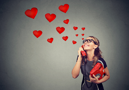 Smiling beautiful woman in love talking on the phoneの写真素材