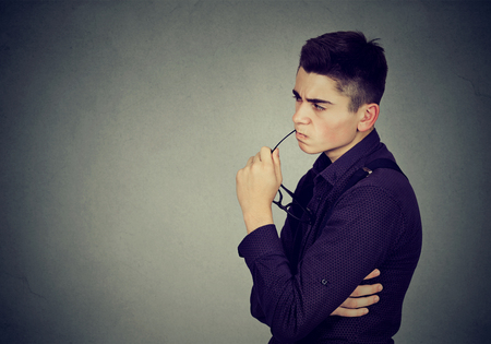 Suspicious doubtful young man の写真素材