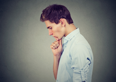 Sorrowful young man thoughtful looking downの写真素材