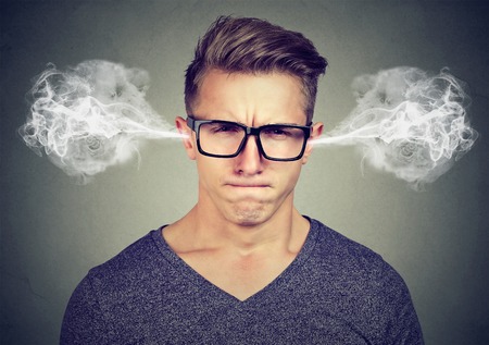 Angry young man, blowing steam coming out of ears, about to have nervous breakdown isolated on gray background. Negative human emotions facial expression feelingsの写真素材
