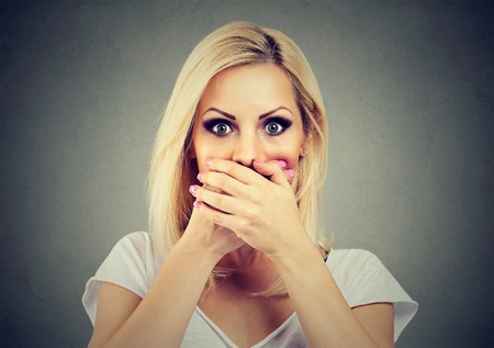 woman covering her mouth with hands scared to speak out about abuse and domestic violenceの写真素材