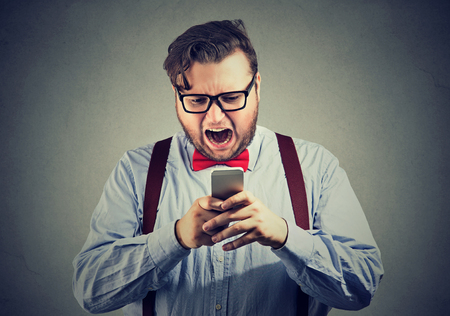 Obese man shouting at smartphone being extremely angry. の写真素材