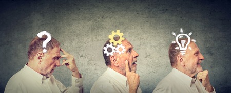Emotional intelligence. Side view of an elderly man thoughtful, thinking, finding solution with gear mechanism, question, lightbulb symbols. Human face expressionの写真素材