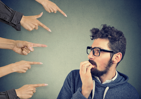 Anxious man judged by different hands. Concept of accusation of guilty guy. Negative human emotions face expression feeling  の写真素材