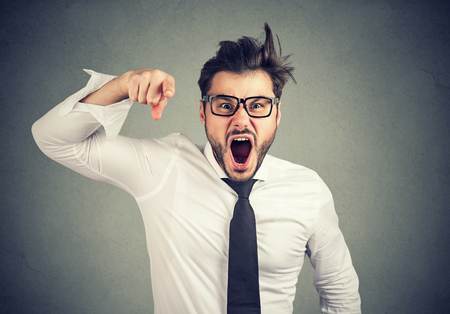 Angry young mad business man accusing someone screaming の写真素材
