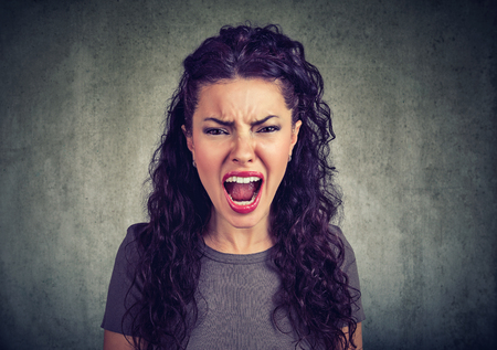 Closeup of young woman screaming at cameraの写真素材