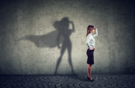 Side view of a business woman imagining to be a super hero looking aspired.の写真素材