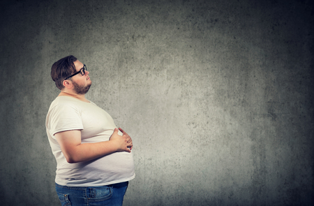Overweight young man with big bellyの写真素材