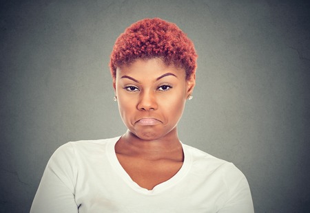 Displeased upset female frowns face as going to cry, being discontent and unhappy isolated on gray...