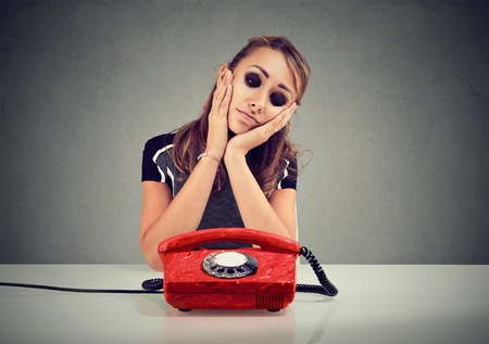 Desperate sad woman waiting for someone to call herの写真素材