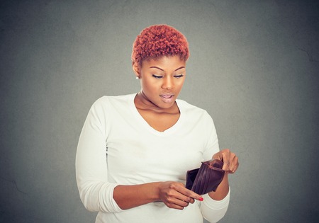 Sad poor young woman showing her empty wallet