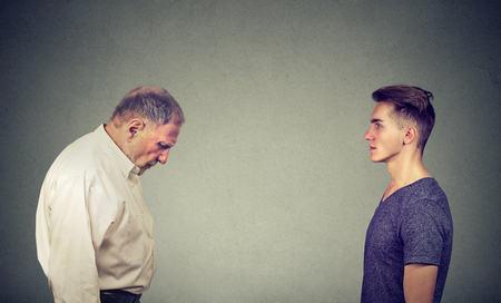 Young handsome man looking at elder depressed himselfの写真素材