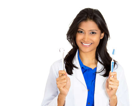 Closeup portrait of young confident, smiling, cheerful female oral health care professional, dentist, showing toothbrush and tongue scraper isolated on white background.の写真素材