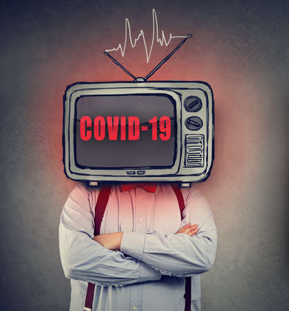 Man with TV set instead of a head watching non stop Coronavirus newsの写真素材