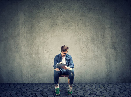 man sitting on a chair filling out a job application formの写真素材
