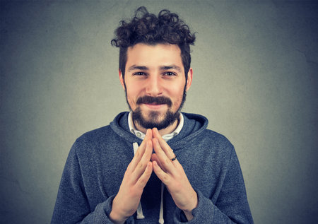 Man clasping hands and smiling