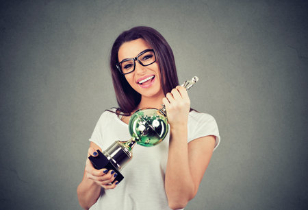 excited young woman winning a trophyの写真素材