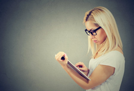 Portrait of a serious blond woman using tablet computerの写真素材