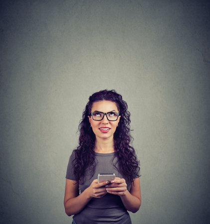Happy woman with a cellphone looking upの写真素材