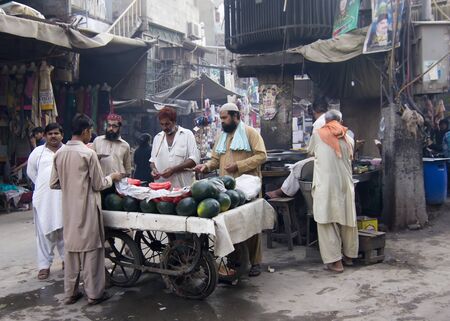 Lahore, Pakistan - May 17, 2013: In 40C degrees and frequent load shedding passers-by stop for fresh watermelon at Anarkali bazaarのeditorial素材
