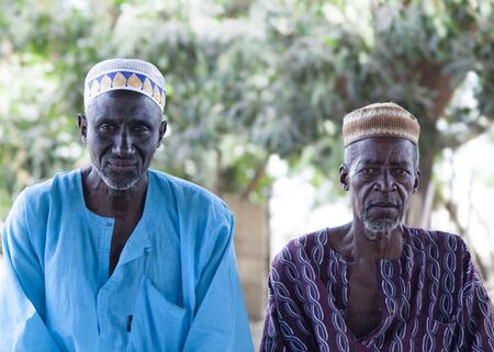 Gabu, Guinea-Bissau - March 29, 2014: Portrait of two african village elders wearing traditional clothes and muslim caps during a village meeting regarding the presidential elections in 2014のeditorial素材