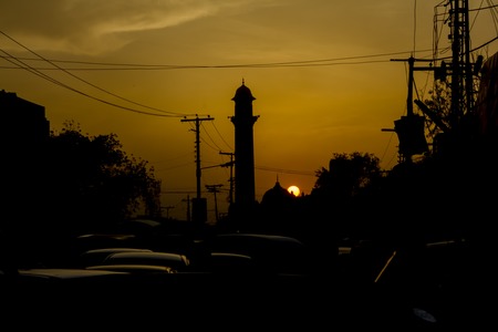 Mosque silhouette by sunset and in heavy traffic jam in Lahore, Pakistanの写真素材