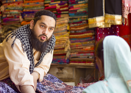 Pakistan, Lahore - May 13, 2013: Vendor and client bargaining over textile prices at  Anarkali bazarのeditorial素材