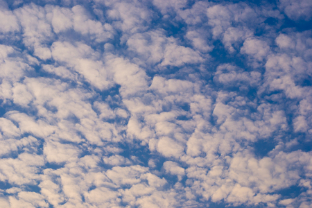 Bright blue sky with clouds and sunlightの写真素材